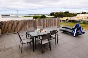 a patio with a table and chairs and a couch at The Apollo in Apollo Bay