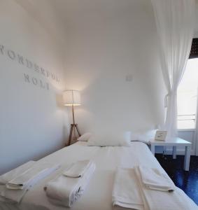 un letto bianco in una stanza con finestra di WONDERFUL NOLI - appartamento Noli Liguria Italia a Noli