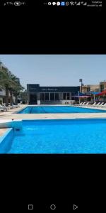 a large blue swimming pool with a building in the background at فنادير in Hurghada