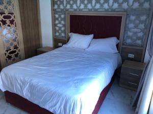 a bedroom with a large bed with a blue blanket at فنادير in Hurghada