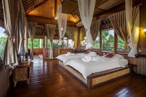 een slaapkamer met 2 bedden in een kamer met ramen bij Villa Sujati in Ubud