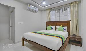 a bedroom with a bed and a window at Rithikha Inn Crest in Chennai