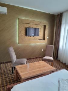 a room with a table and two chairs and a tv at Hotel PEKING in Sarajevo