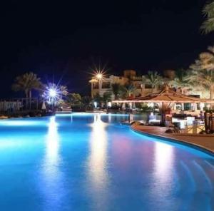 a large swimming pool at night with blue lights at Private villa North Coast in Dawwār Muḩammad Abū Shanab