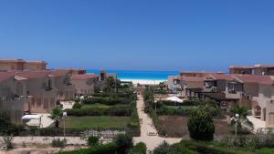 a row of houses with the beach in the background at Private villa North Coast in Dawwār Muḩammad Abū Shanab