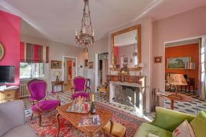 ein Wohnzimmer mit einem Kamin und lila Stühlen in der Unterkunft Magnifique maison de famille - 3 mn à pied du centre in Uzès