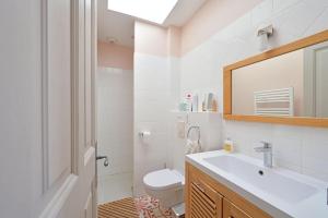 ein Badezimmer mit einem Waschbecken, einem WC und einem Spiegel in der Unterkunft Magnifique maison de famille - 3 mn à pied du centre in Uzès