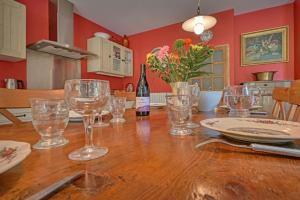 einen Tisch mit Gläsern und eine Flasche Wein in der Unterkunft Magnifique maison de famille - 3 mn à pied du centre in Uzès