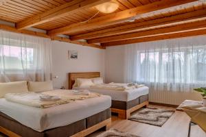 2 Betten in einem Zimmer mit Holzdecken in der Unterkunft Grüner Baum in Külsheim