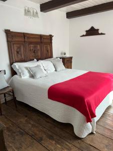 a bedroom with a large bed with a red blanket at Bnbook Ca Du Val in Terrabona