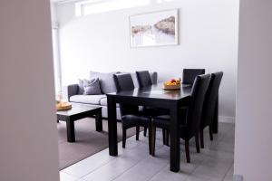 a dining room with a black table and black chairs at The Apollo in Apollo Bay