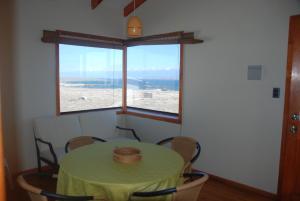a room with a table and a large window at Cabanas Las Hualas in Punta de Choros