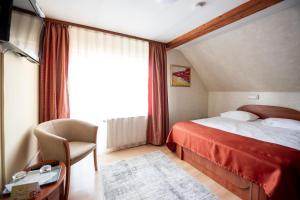 Habitación de hotel con cama, silla y ventana en Pensiunea Andy, en Brasov