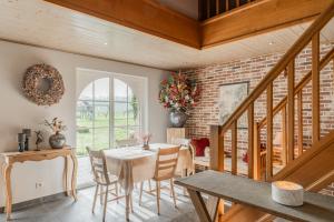 a dining room with a table and chairs and a brick wall at B&B De Bergvallei in Oedelem