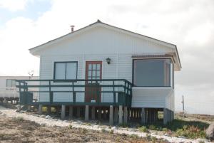 a house with a large balcony on the beach at Cabanas Las Hualas in Punta de Choros