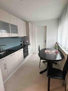 a kitchen with a table and chairs and a sink at Neubau in Zürich Oerlikon in Zurich