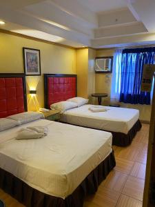 a hotel room with two beds and a window at Sugarland Suites in Ormoc