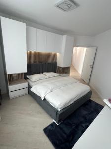 um quarto com uma cama grande e lençóis brancos em Sunny Accommodation Suceava 56 em Suceava