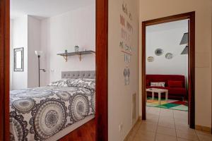 利沃諾的住宿－CASA PATTI，一间卧室配有一张床和一张红色的沙发