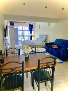 ein Wohnzimmer mit einem Tisch und einem blauen Sofa in der Unterkunft Beachfront bliss villa in Diani Beach