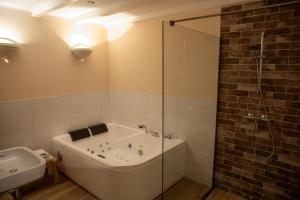 Das Bad ist mit einer Badewanne und einer Glasdusche ausgestattet. in der Unterkunft Bed and Breakfast Lauwersstate in Paesens