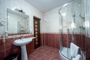 a bathroom with a sink and a shower and a toilet at Pensiunea Andy in Braşov