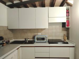 cocina con armarios blancos y tostadora en Appartamento Centro Storico - Perugia, centro, en Perugia