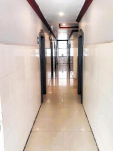 an empty hallway with doors and tile walls at THE LIVIN Residency in Visakhapatnam