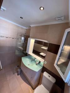 Villa face aux iles d'Or, Plage de la Capte في هييريس: حمام مع مرحاض ومغسلة ومرآة