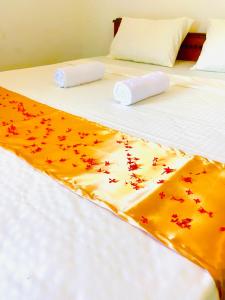 ein Bett mit roten und orangefarbenen Sternen darauf in der Unterkunft Marina Way Hotel in Arugam Bay