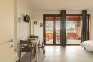 una camera con tavolo da pranzo e una camera con una camera da letto di Agriturismo I sentieri del Vino - Lago Lucone a Polpenazze del Garda