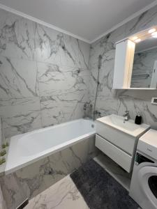 uma casa de banho com uma banheira branca e um lavatório. em Sunny Accommodation Suceava 56 em Suceava