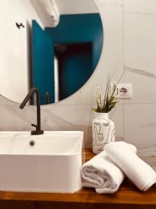 a bathroom sink with a towel and a mirror at Modern Loft Rho Fiera Milano in Rho