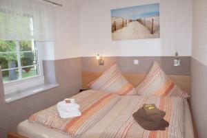 a bedroom with a bed with towels and a window at Beckerhof - ABC54 in Dorf Mecklenburg