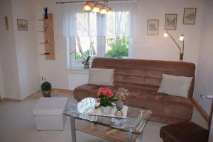 a living room with a brown couch and a glass table at Beckerhof - ABC54 in Dorf Mecklenburg