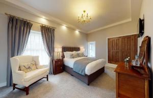 a bedroom with a bed and a chair and a piano at Newbay House Wexford in Wexford