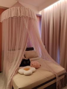 un lit à baldaquin avec un animal rembourré dans l'établissement "CAT THEME" 2 Bedrooms at Jelutong, Urban Suites, à Jelutong