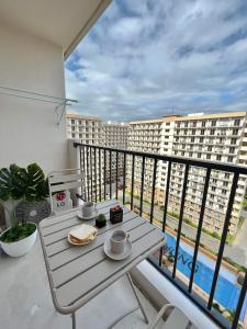 einen Balkon mit einem Tisch und Blick auf ein Gebäude in der Unterkunft RichAirbnb Cebu in Lapu Lapu City