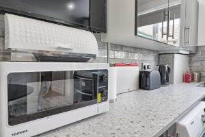 a kitchen with a microwave and a counter top at Lavish Rayleigh Apartment - Small-Med dog OK in Rayleigh