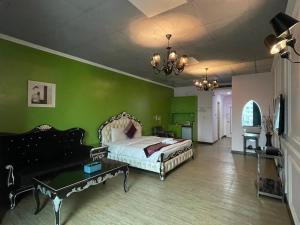 a bedroom with a bed and a green wall at Neo Sky Hotel in Kaohsiung