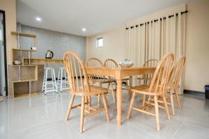 a dining room with a wooden table and chairs at MountainviewKhaoyai in Ban Khanong Phra Klang (1)