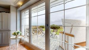 a room with sliding glass doors and a view of the ocean at Sylt pur in Munkmarsch