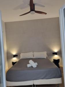 a bedroom with a bed with two white towels on it at HOUSE Sevillana Parking in Seville