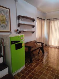 einen grünen Kühlschrank in einem Zimmer mit einem Tisch in der Unterkunft Chiang Mai Homey in Chiang Mai