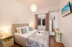 a small bedroom with a bed and a window at Elounda Summer Apt in Elounda
