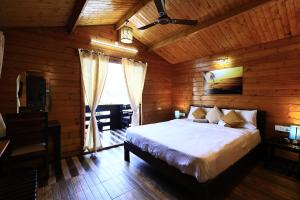 a bedroom with a bed in a wooden cabin at Sal Riviera in Cavelossim