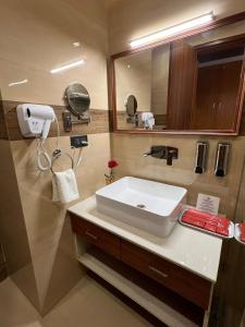 a bathroom with a white sink and a mirror at The Velvista Hotel in Muzaffarnagar