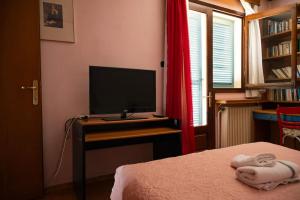 a bedroom with a bed and a television on a desk at Carte Postale in Kastoria