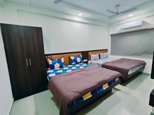 Heritage Palace - Bhuj في بهوي: غرفة نوم بسريرين في غرفة
