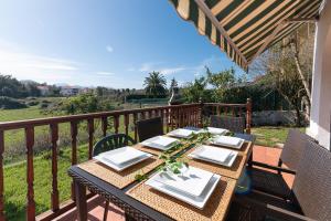 una mesa de madera en un balcón con mesa en Seaside Retreat by Fidalsa, en Argoños